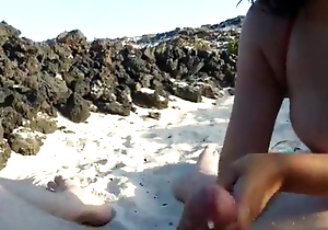 Juvenile Spanish girl gives a irrumation at a influence a rear beach